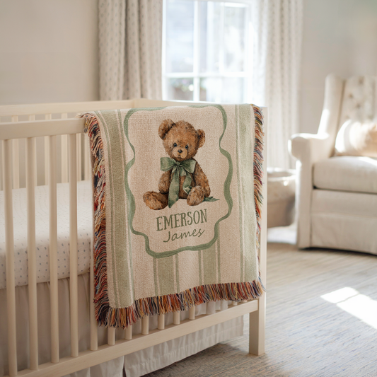 Personalized teddy bear baby blanket with custom name and vintage nursery design draped over crib