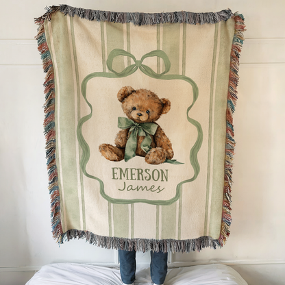 Personalized teddy bear baby blanket with custom name and vintage nursery design draped over crib